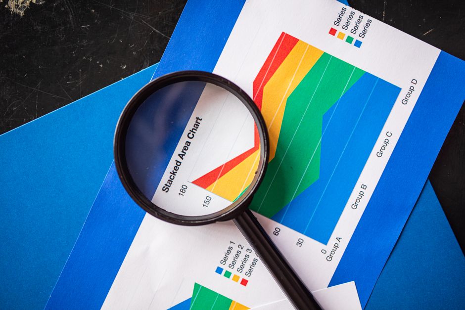 Magnifying glass highlighting stacked area charts for busine