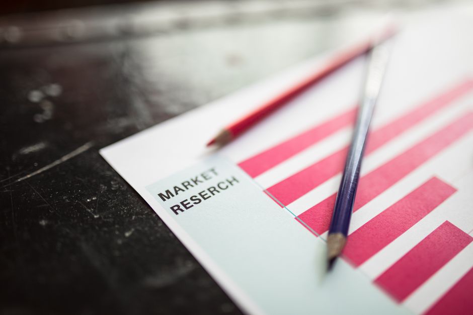 Close-up of market research paper with red graph bars and pe
