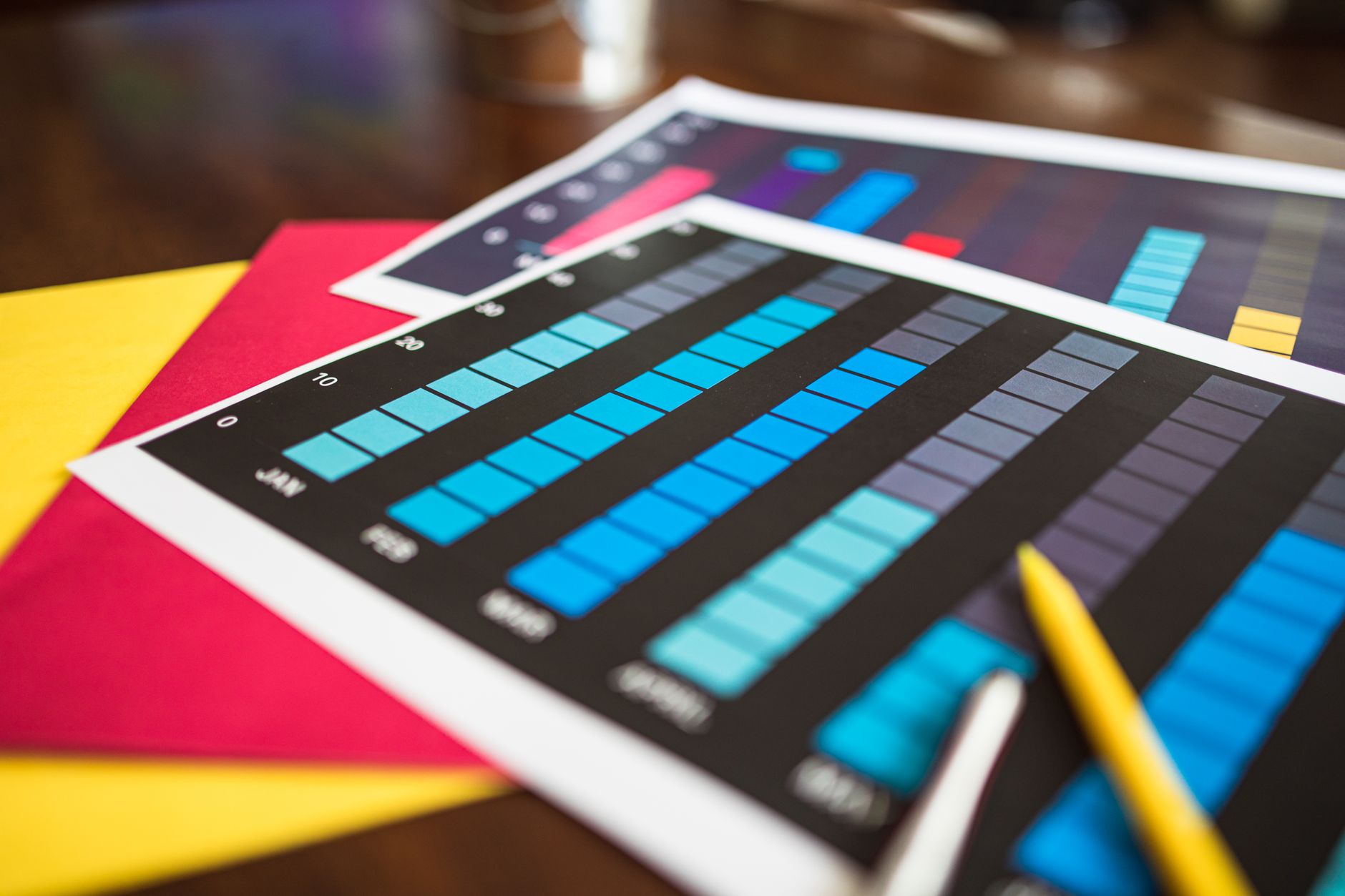 Close-up of colorful financial charts and a pencil on a wood