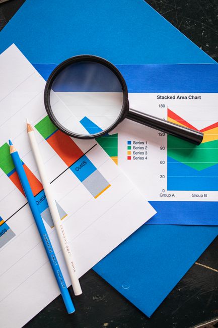 Image of financial charts and magnifying glass, ideal for bu