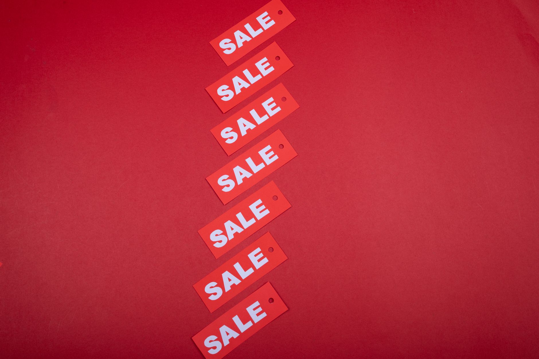 Diagonal row of red sale tags on a red background. Ideal for