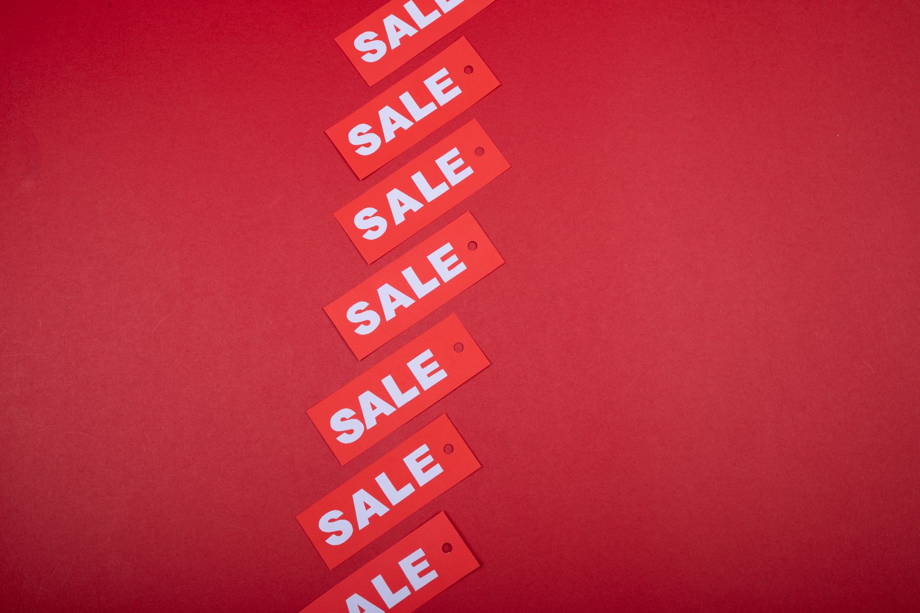 Red sale tags aligned diagonally on a red background, perfec