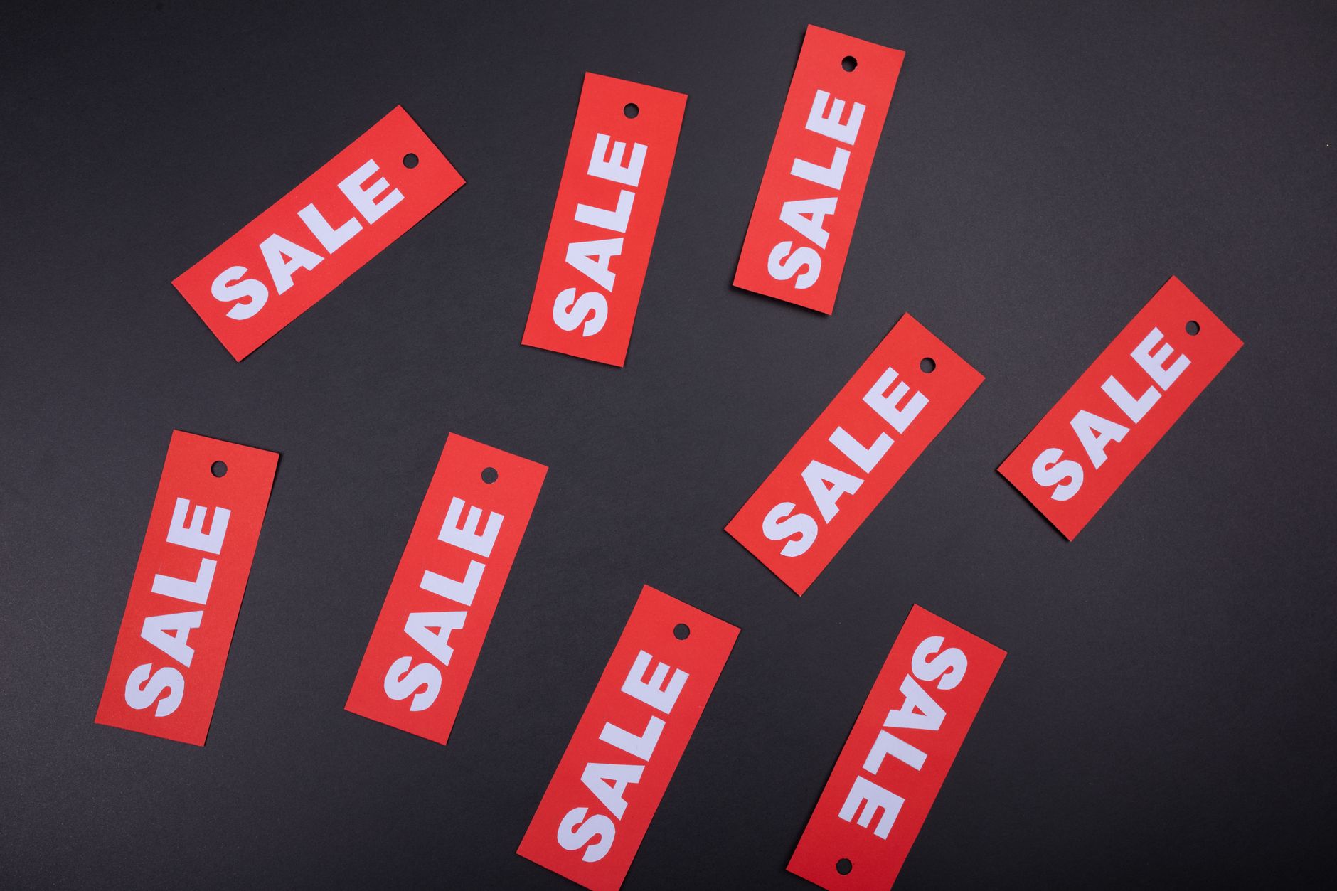 Red sale tags on a black background. Ideal for marketing and