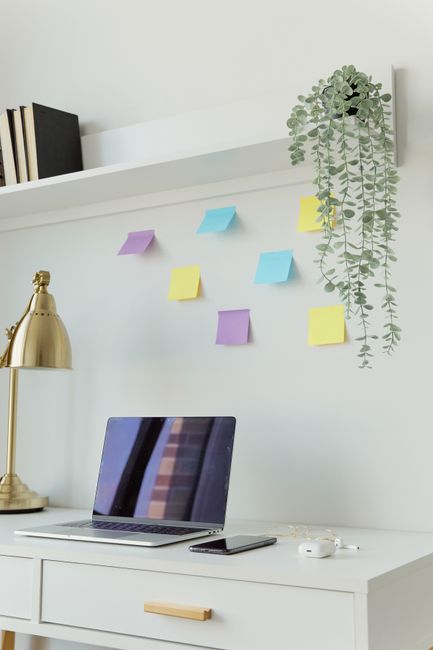A minimalist home office desk with a laptop, smartphone, and