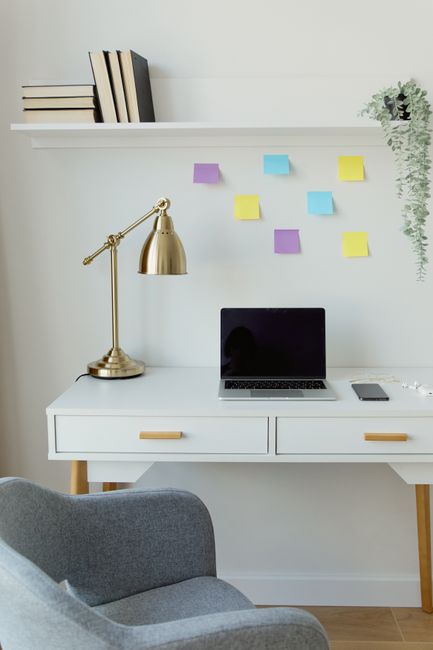 A sleek home office setup featuring a laptop, golden lamp, a
