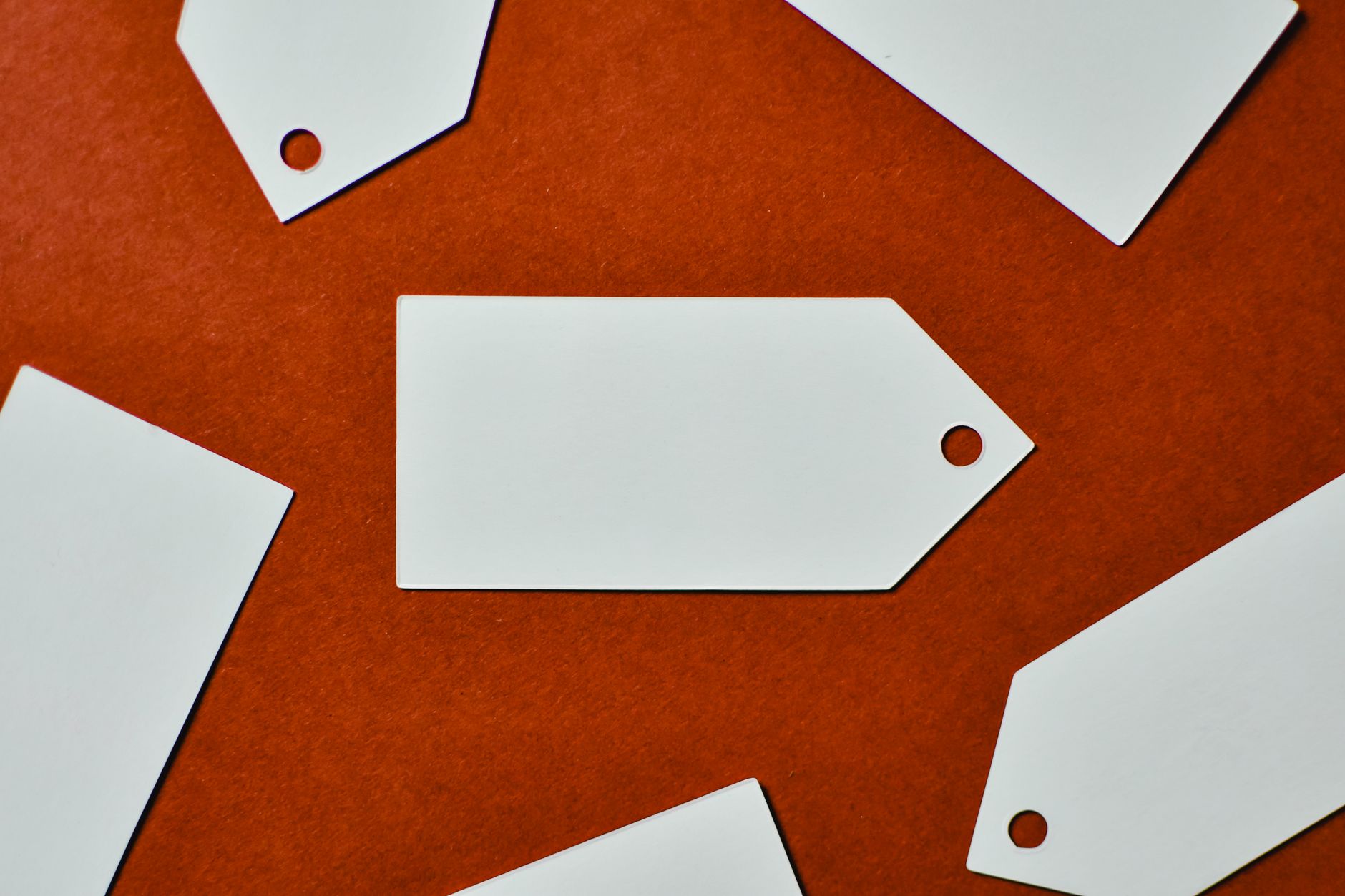 Close-up of white blank tags on a textured red background, p