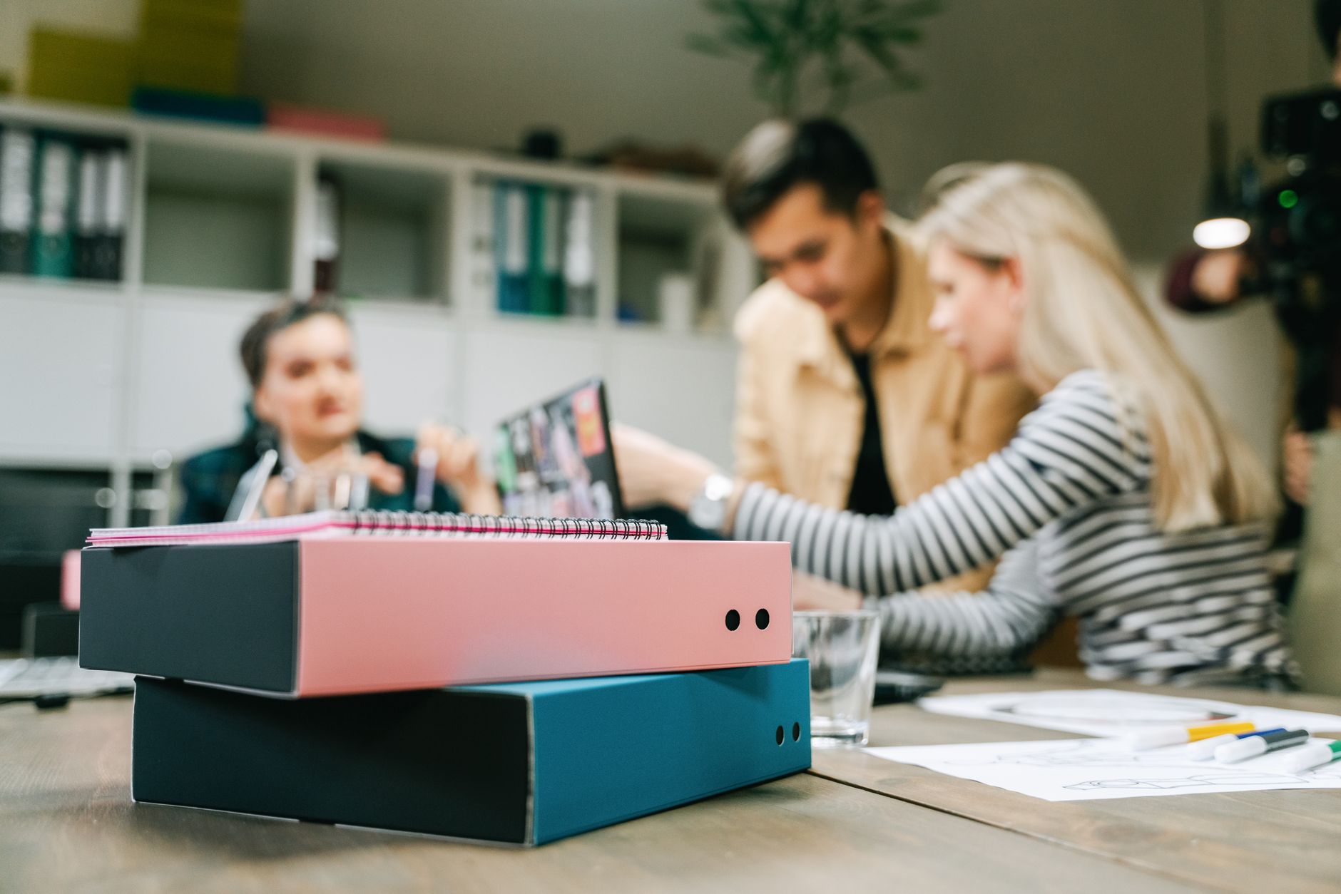 Focused group discussing strategy in an office with binders