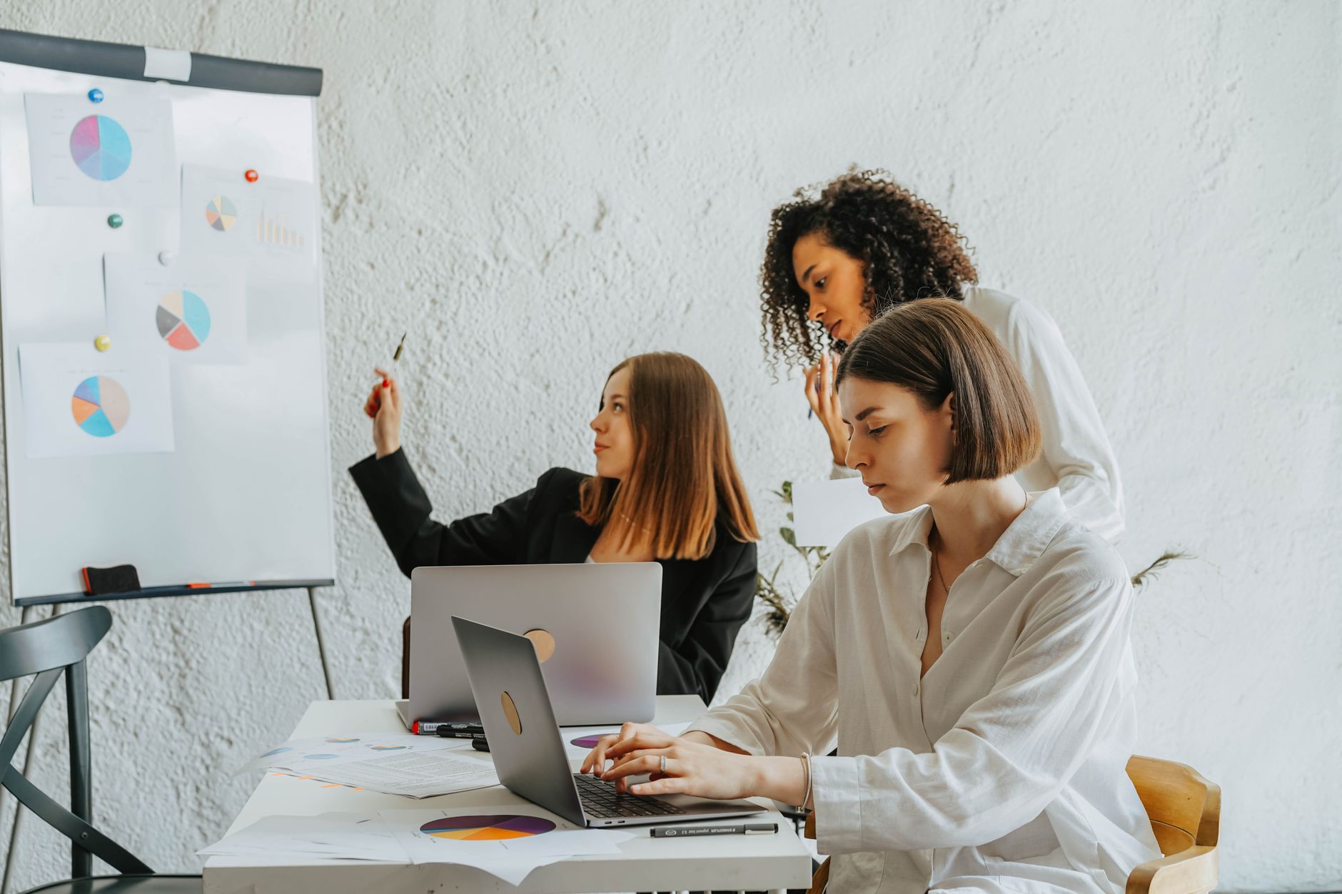 Women working together on a business project with laptops an
