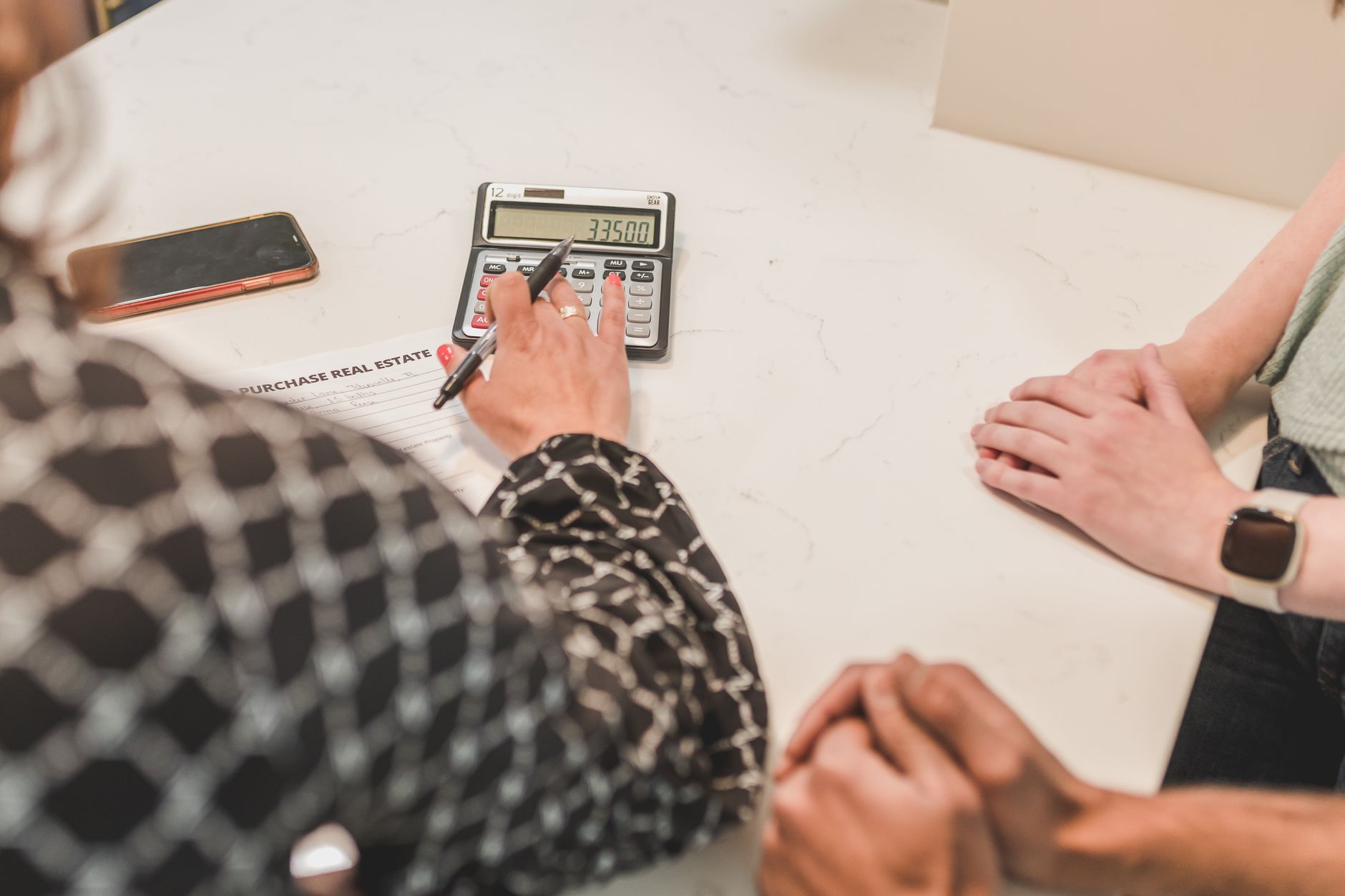 Close-up of hands during a real estate transaction with a ca