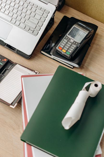 Overhead view of an office desk with laptop, payment termina
