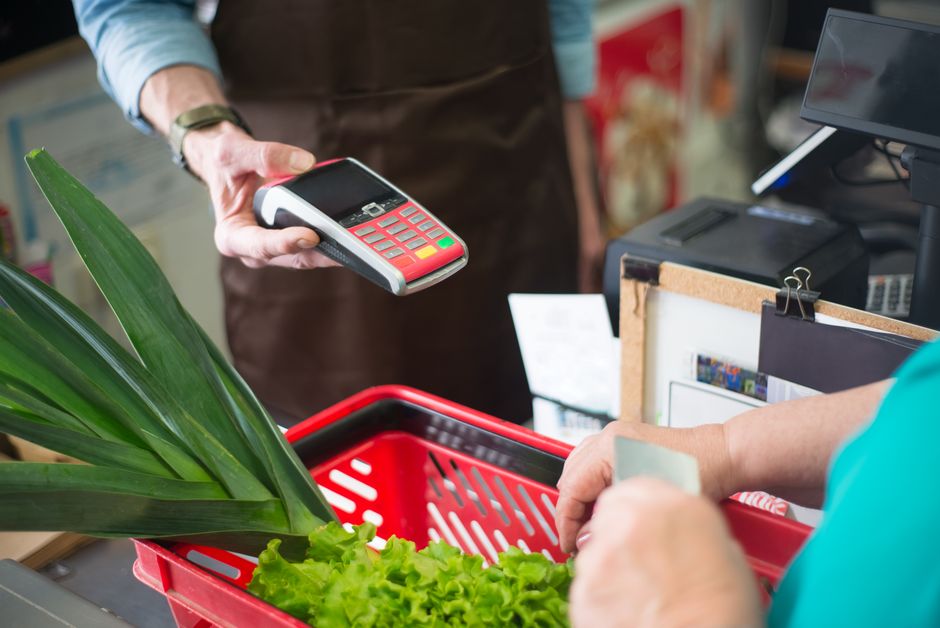 A customer using a contactless payment method at a grocery s