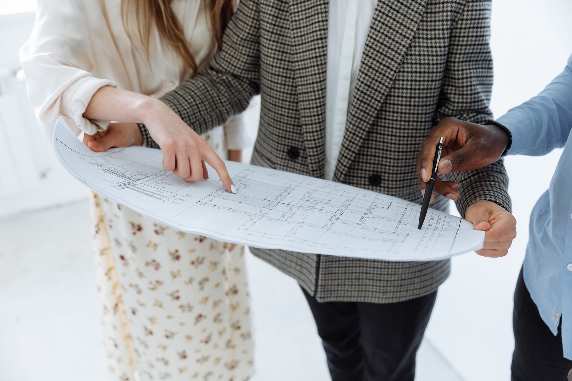 Adults reviewing detailed schematic floor plans indoors for