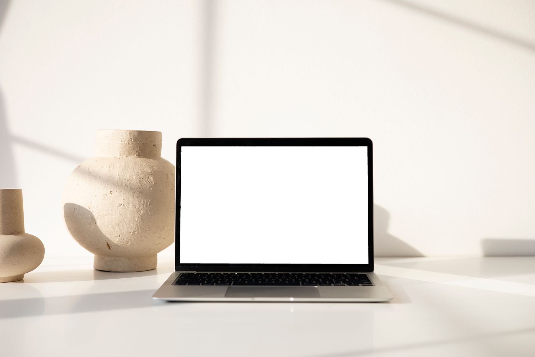 Modern minimalist workspace displaying a laptop with clay va