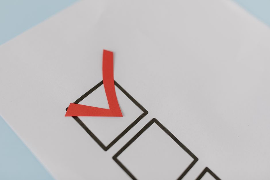 Close-up of a red check mark on a crisp white paper with bla