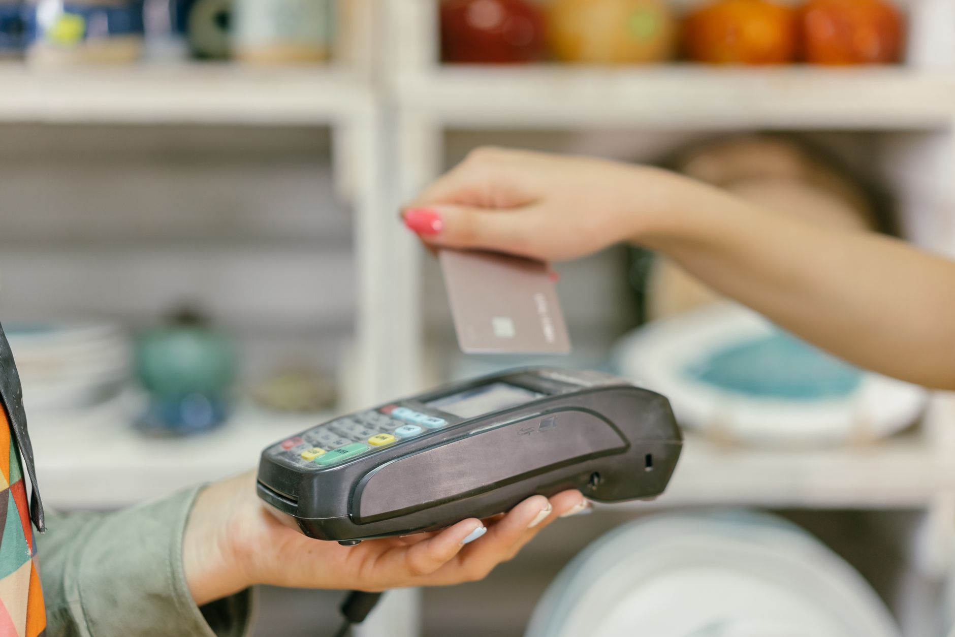 A hand using a credit card for payment at a point of sale te