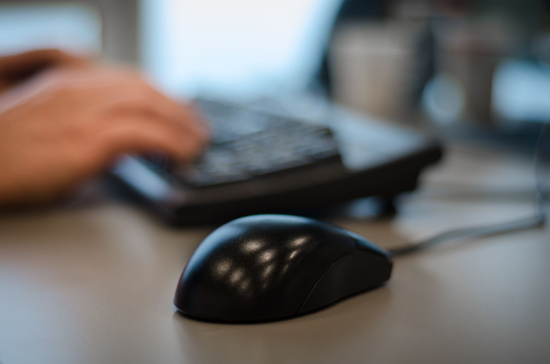 Blurry background with a focus on a computer mouse in an off