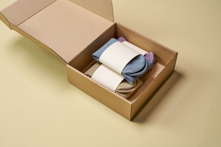 Multicolored socks neatly arranged inside open cardboard pac
