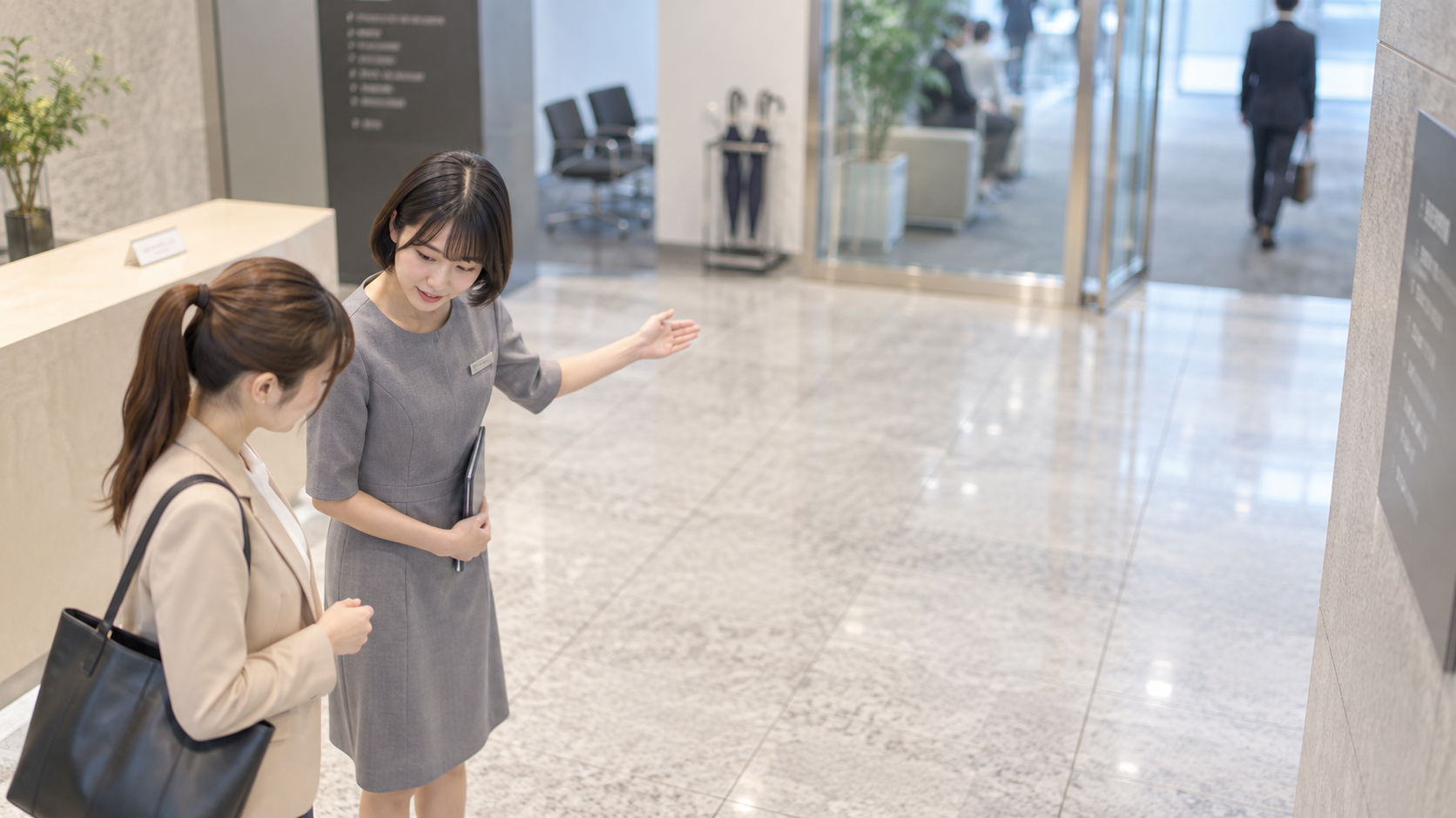 20代前半の日本人女性が来客の案内をしている場面
