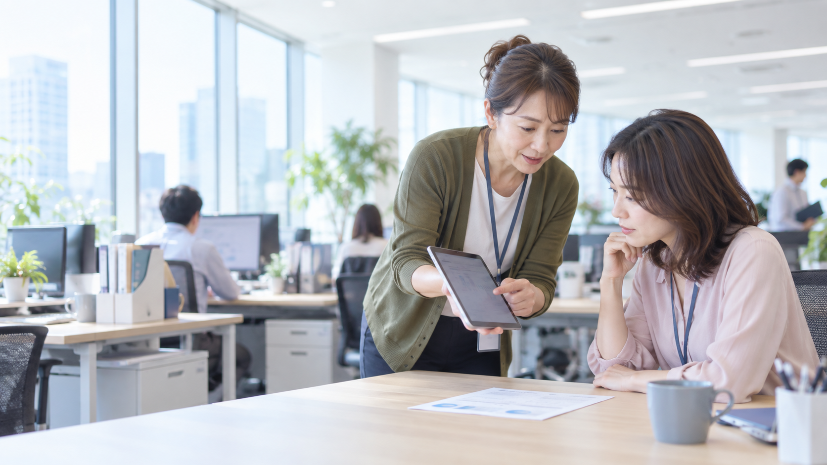 40代前半の日本人女性がタブレットでの提示をしている場面