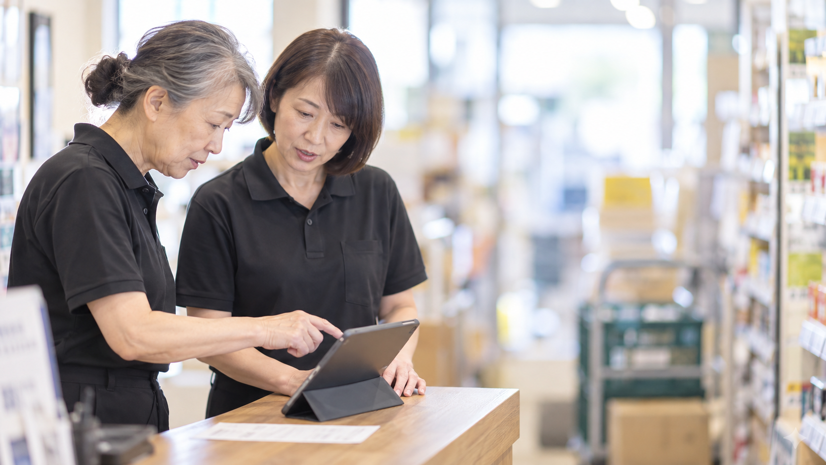 60代前半の日本人女性が店舗カウンターでの受注をしている場面