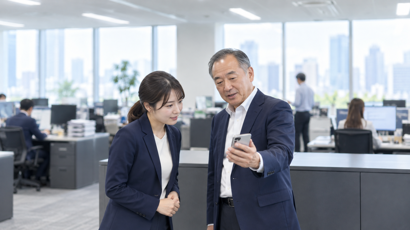 50代後半の日本人男性がスマートフォンの画面提示をしている場面