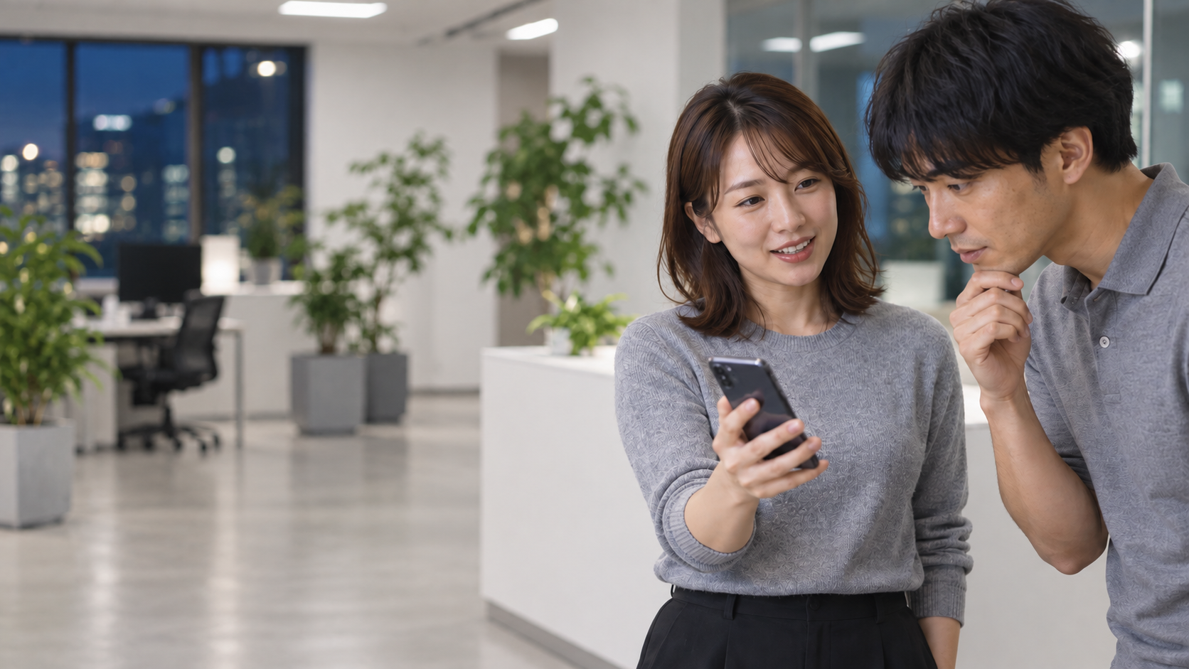 30代前半の日本人女性がスマートフォンの画面提示をしている場面