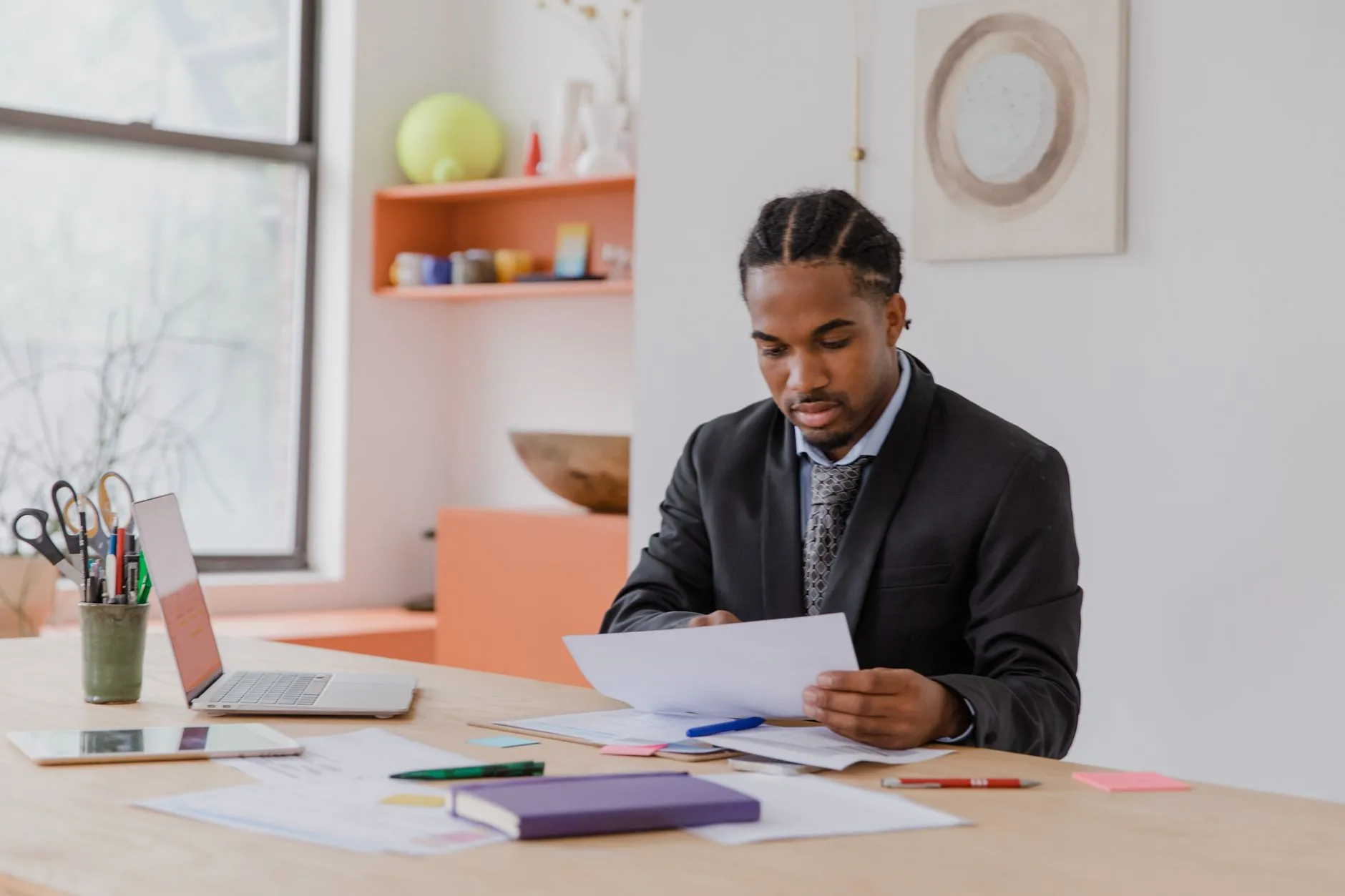 Focused businessman reviewing documents in a modern office setting.
