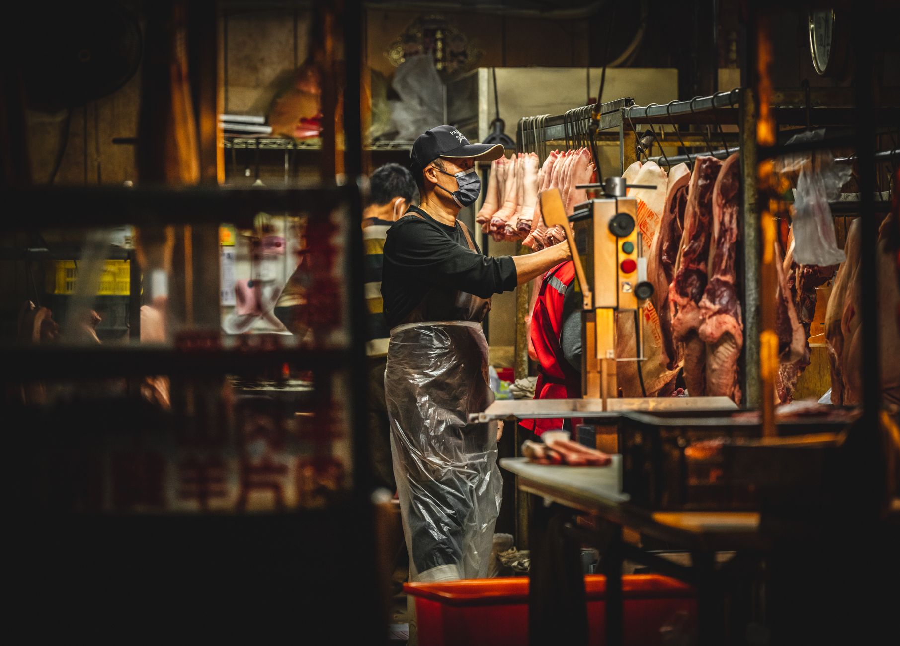 Butchers working in a Miaoli, Taiwan meat market, handling fresh pork.