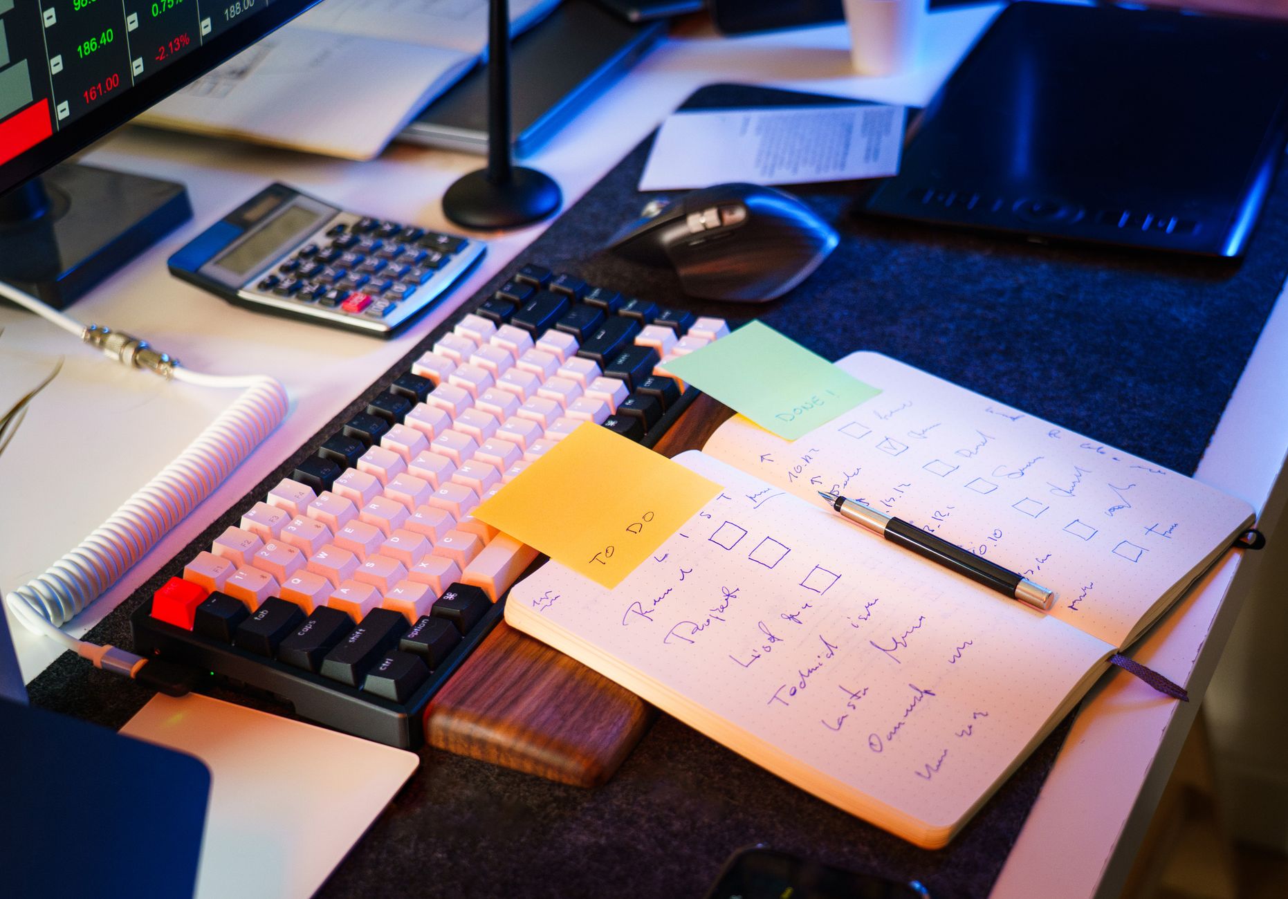 Modern office desk with keyboard, notebook, and checklist for productivity.