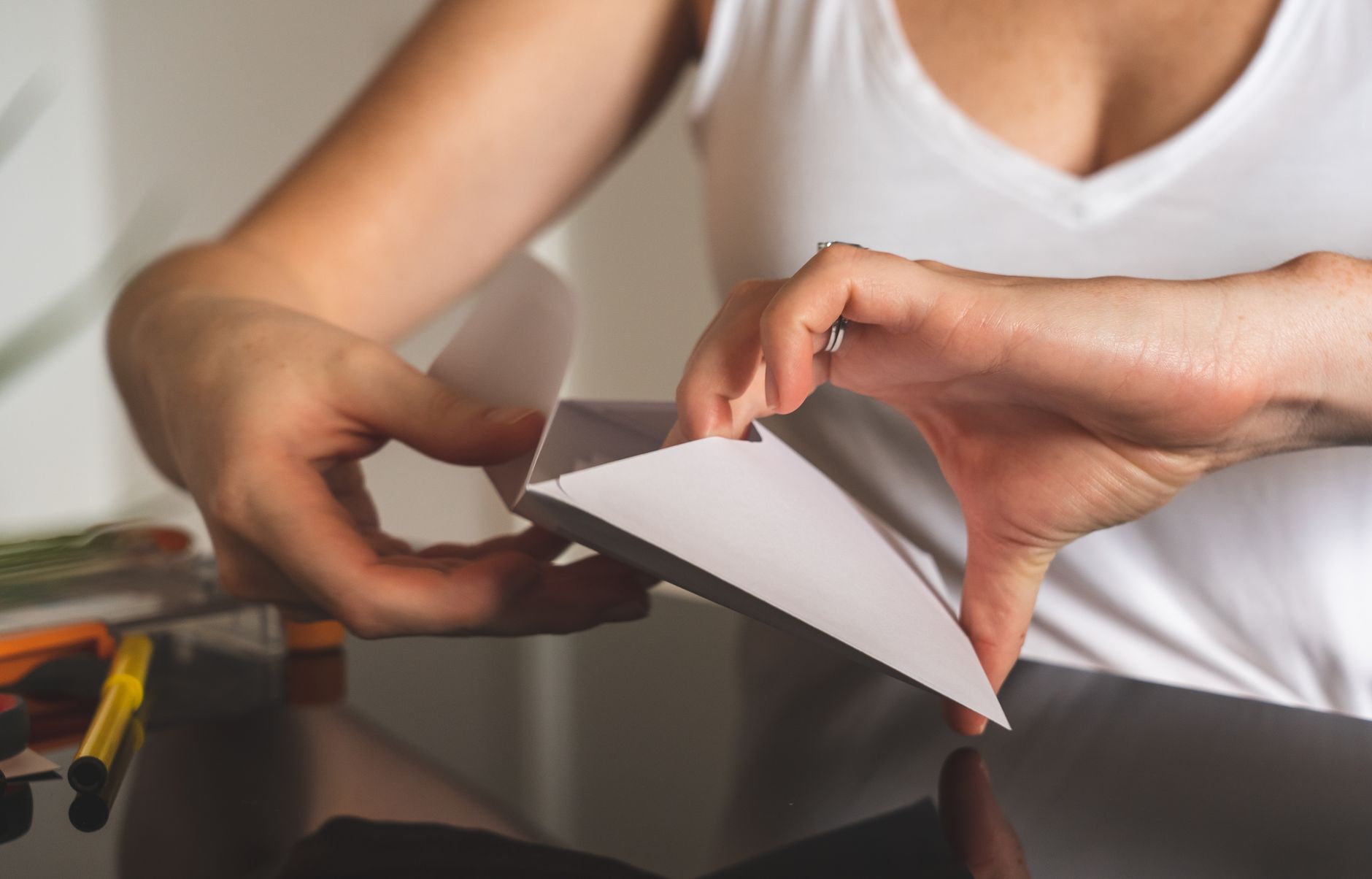 A close-up image showing hands sealing a white envelope on a polished surface. Perfect for business or communication concepts.
