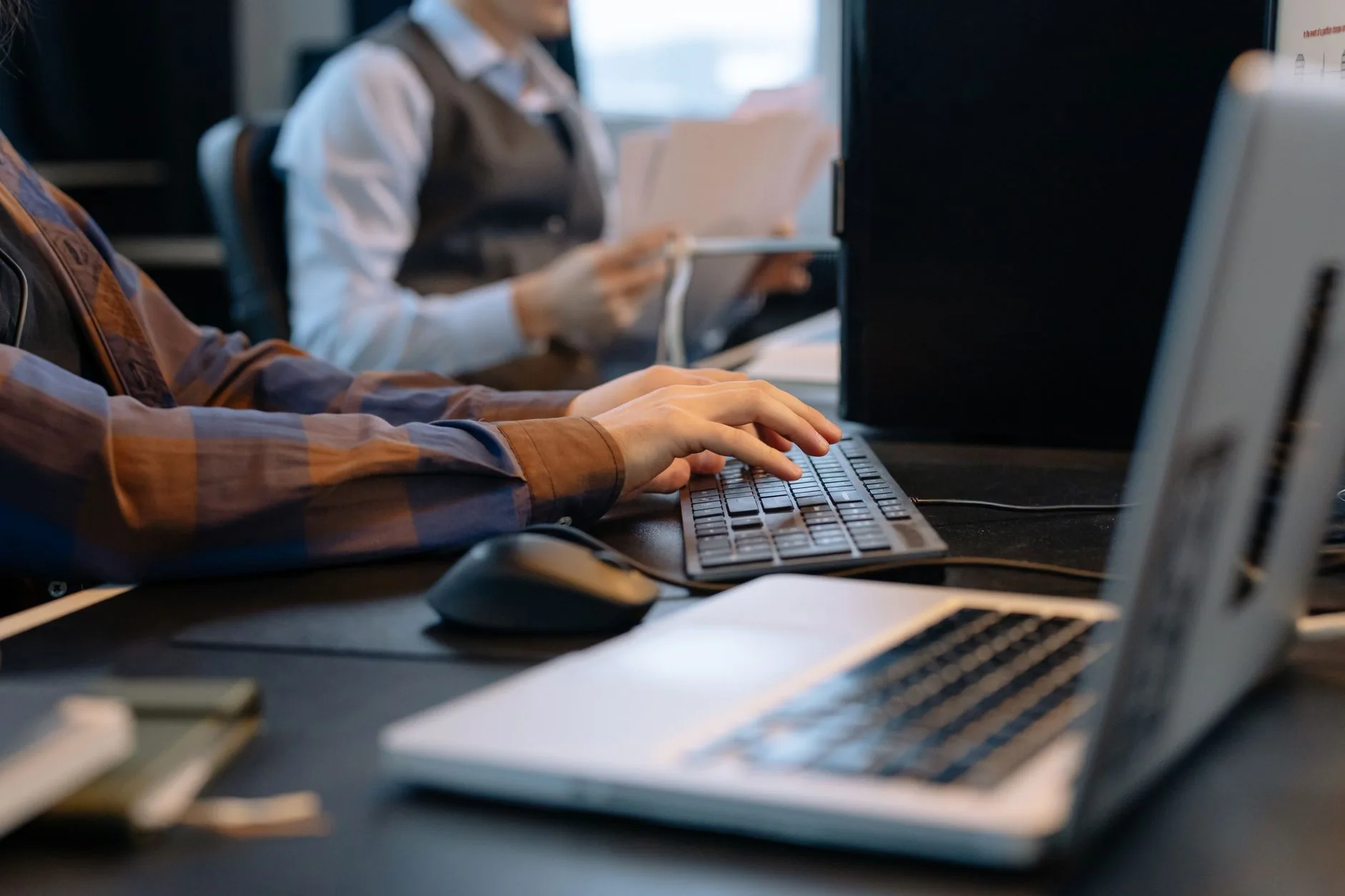 Close-up of office workers engaged in a tech project at a modern workplace.