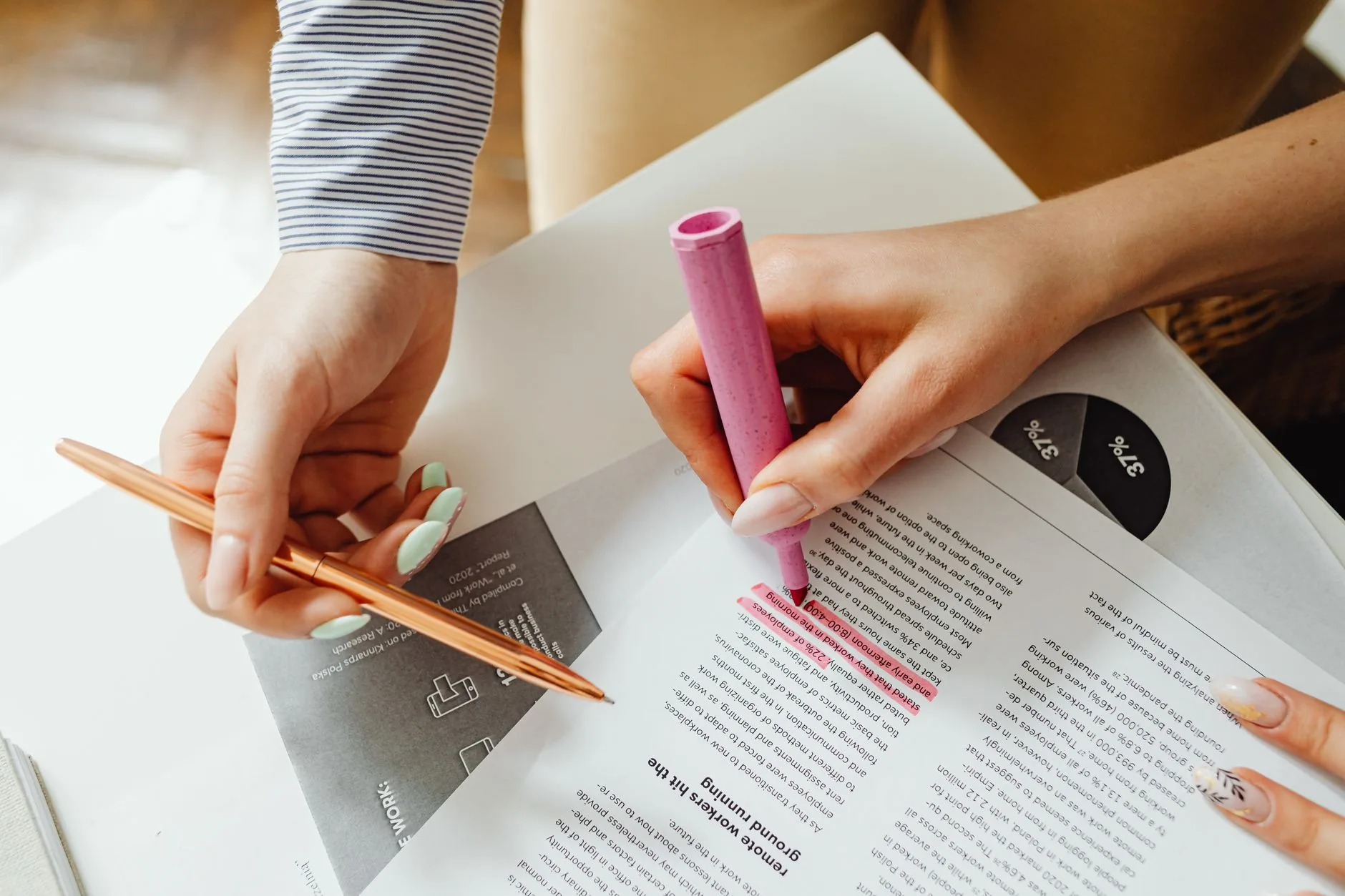 Hands highlighting and taking notes on a document with pen and highlighter.
