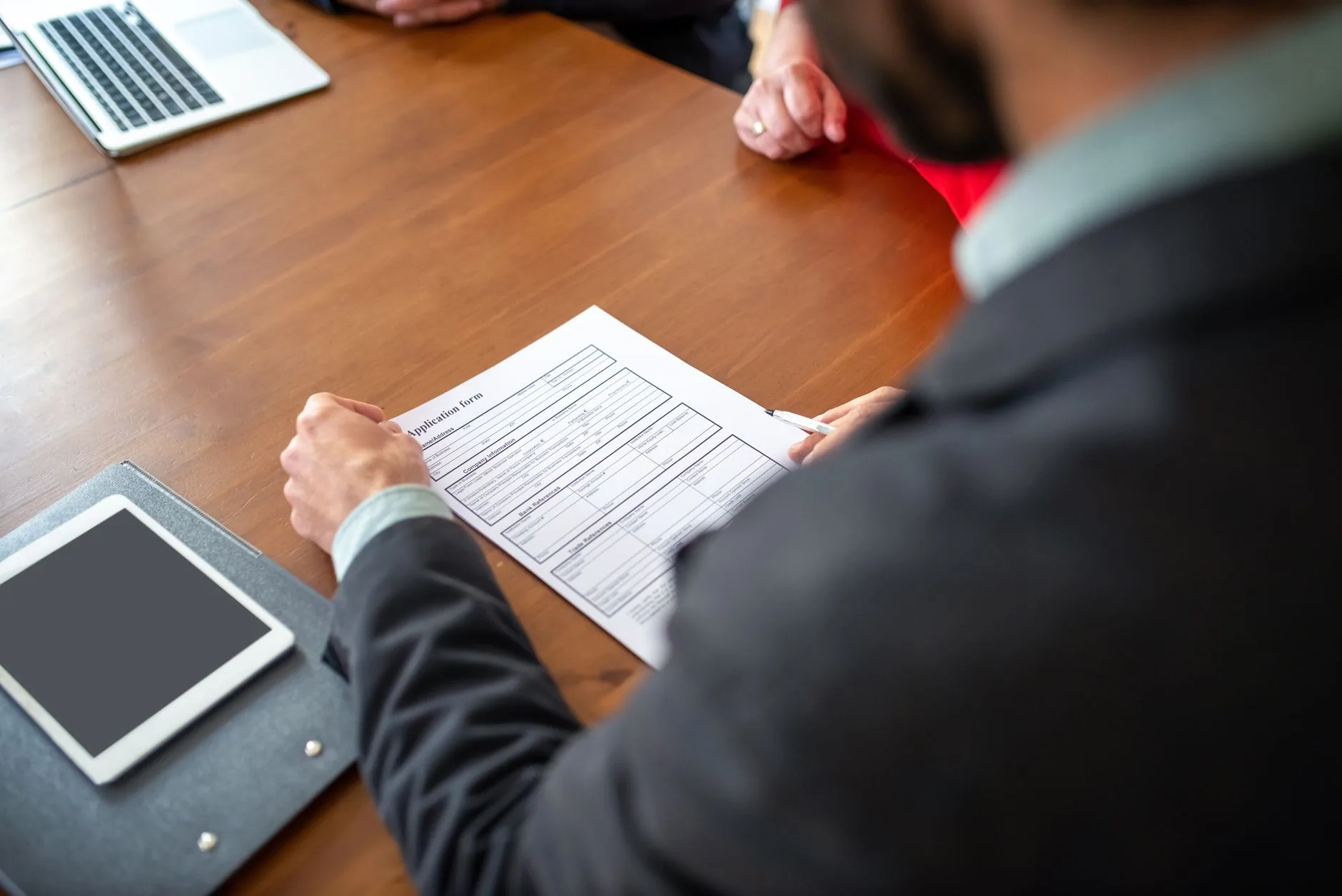 Business professionals reviewing an application form during a meeting.