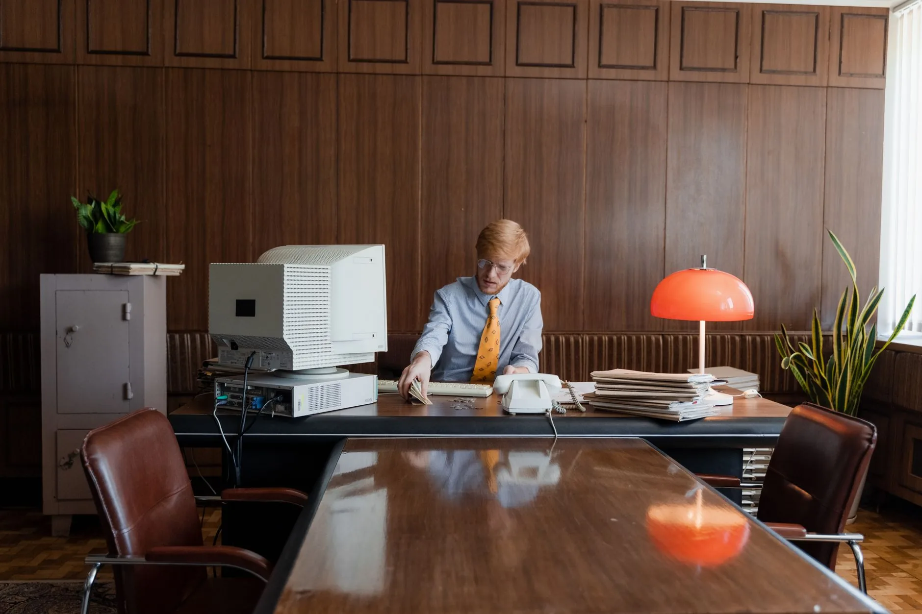 Businessman working in a retro office with vintage computer and decor.