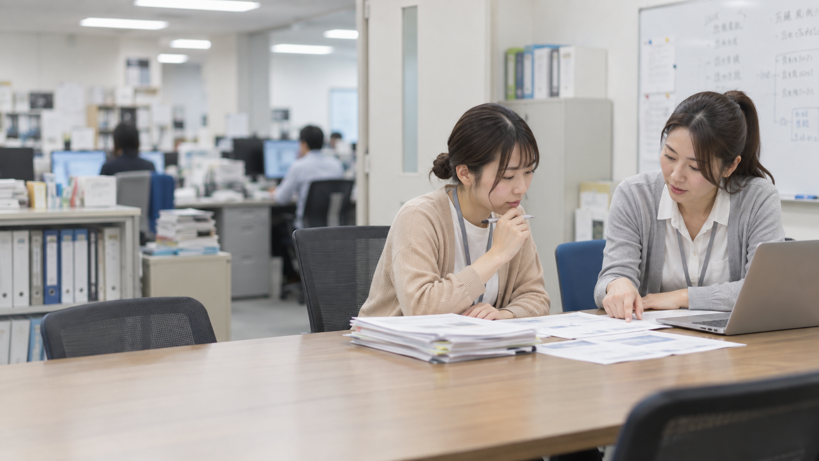 20代前半の日本人女性が小会議室での打ち合わせをしている場面