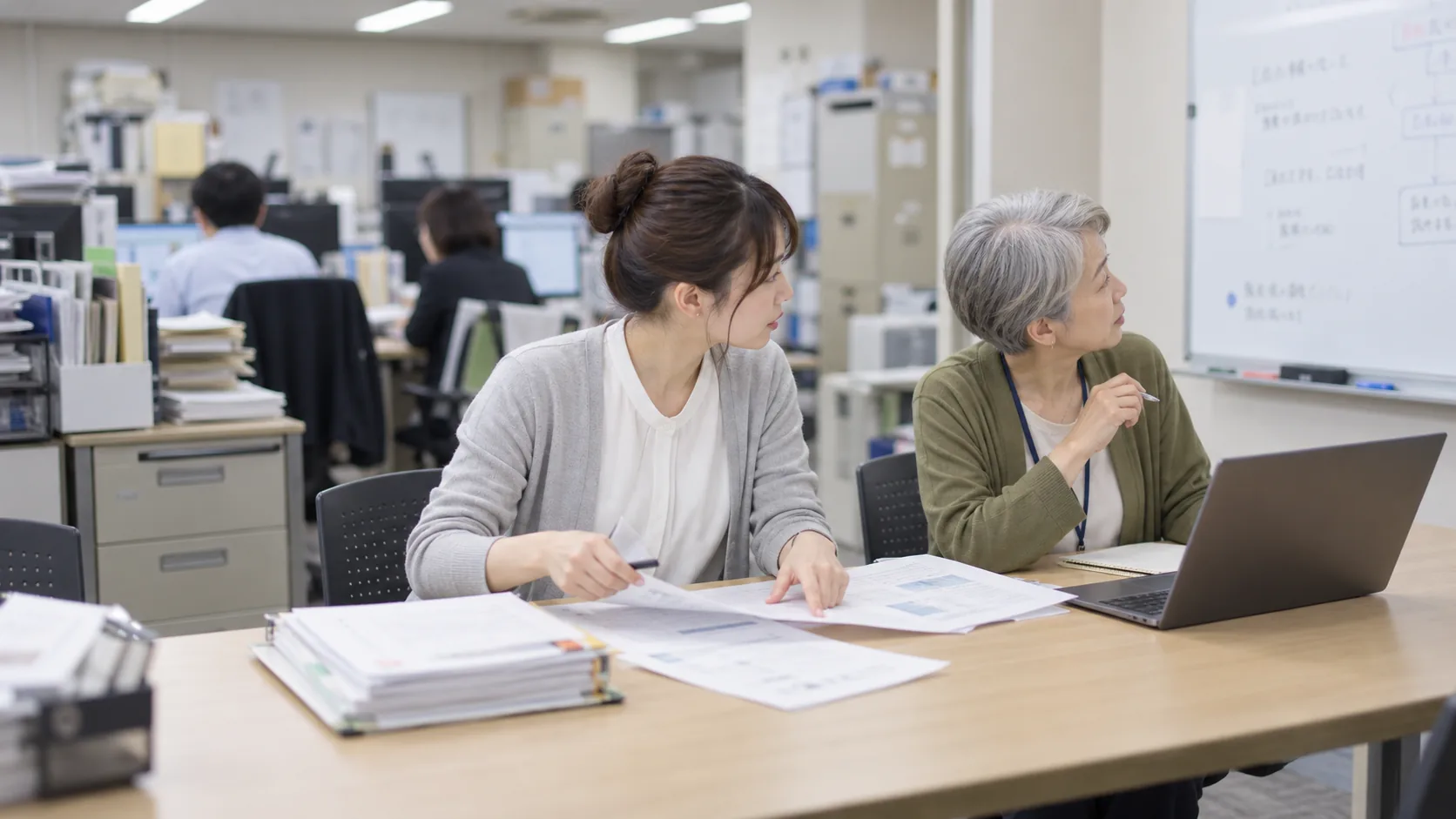 20代後半の日本人女性が小会議室での打ち合わせをしている場面