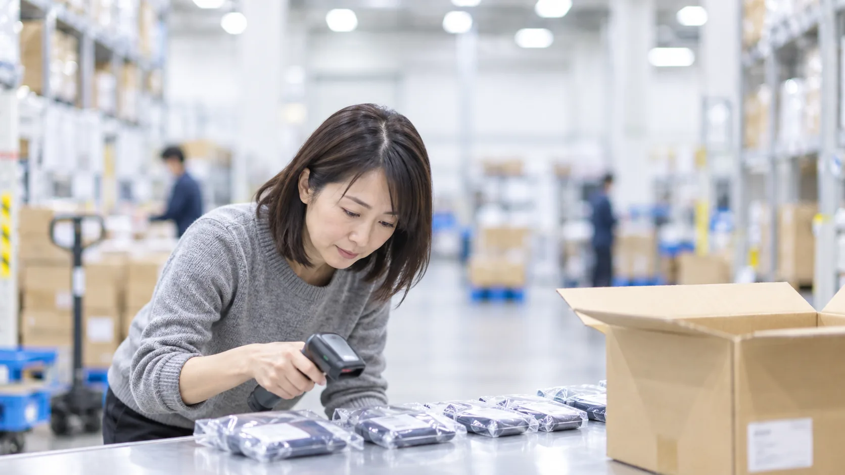 40代前半の日本人女性が検品台での数量確認をしている場面
