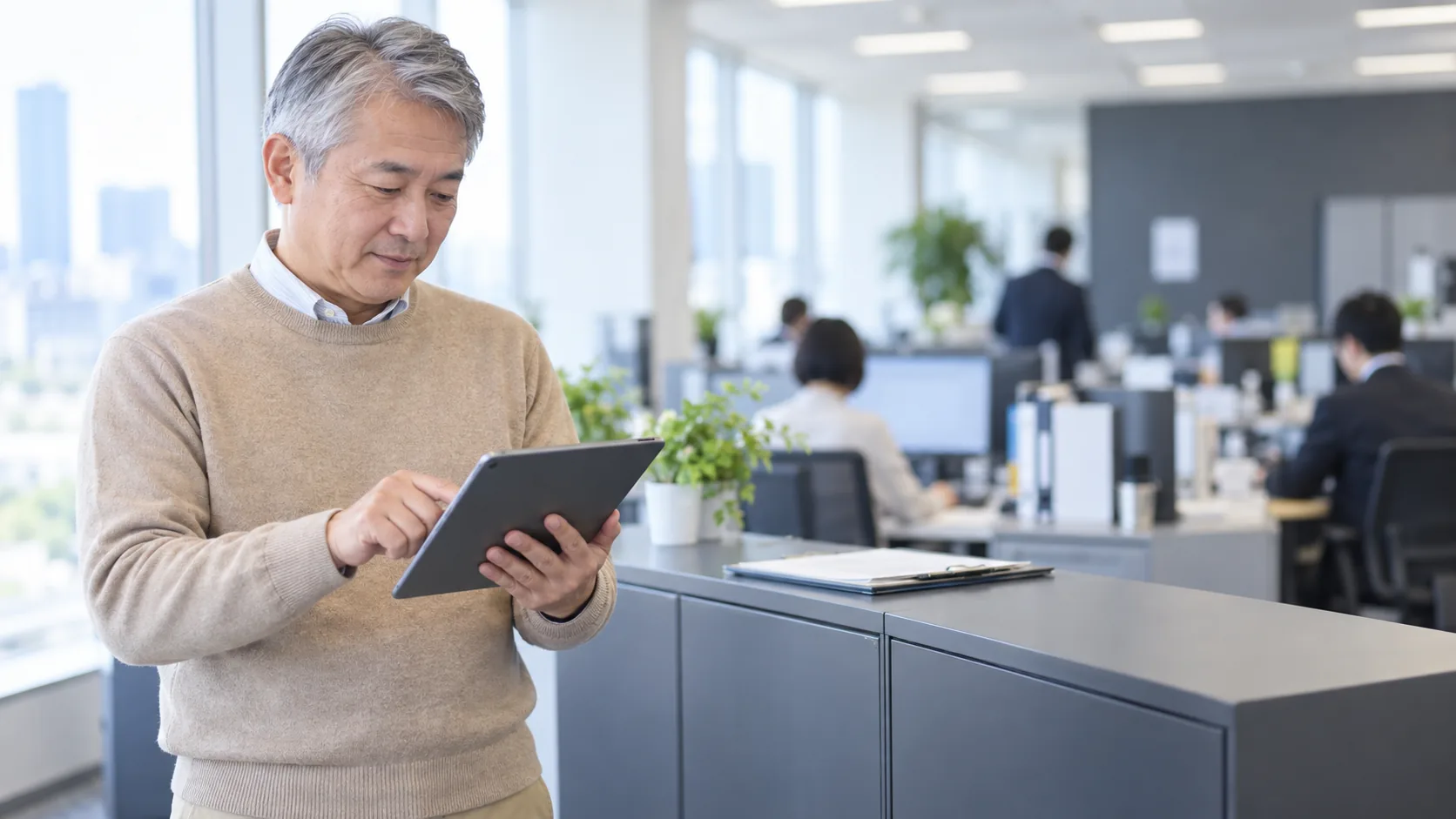 50代後半の日本人男性がタブレットへの入力をしている場面