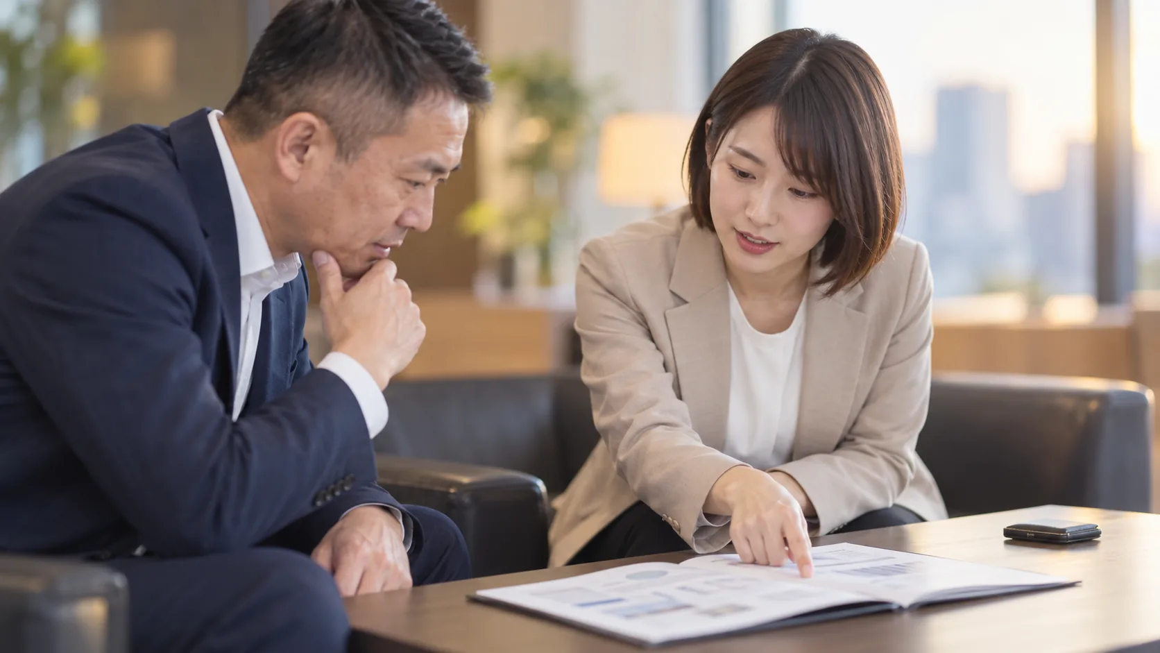 30代前半の日本人女性が提案書の説明をしている場面