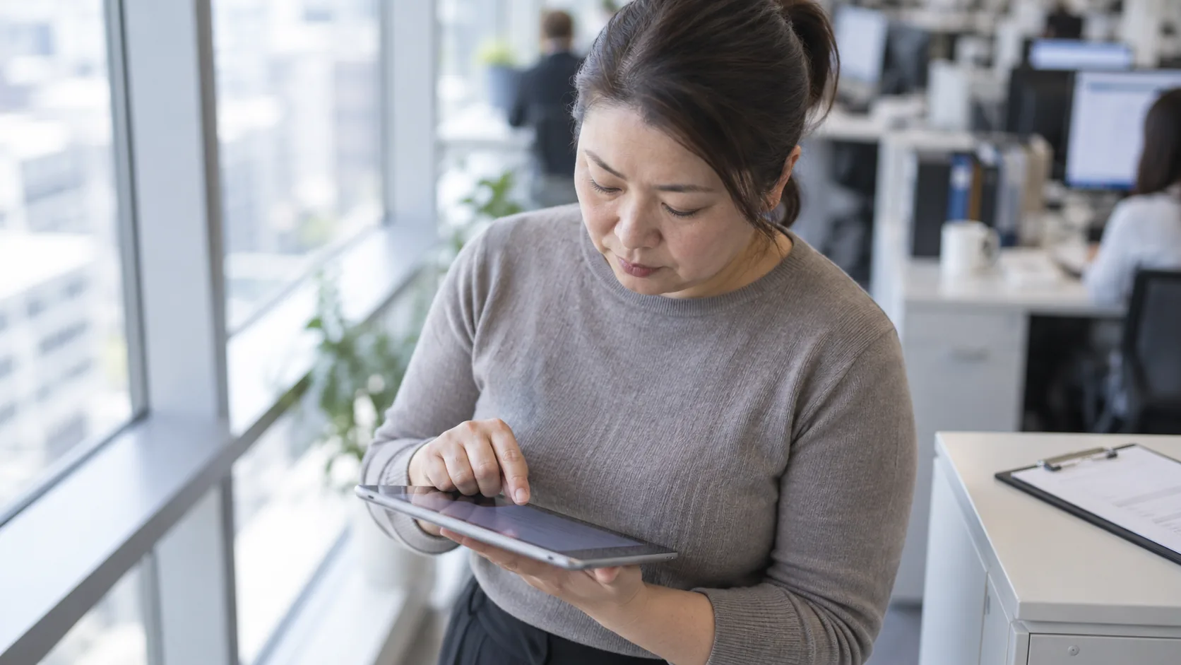 40代後半の日本人女性がタブレットへの入力をしている場面