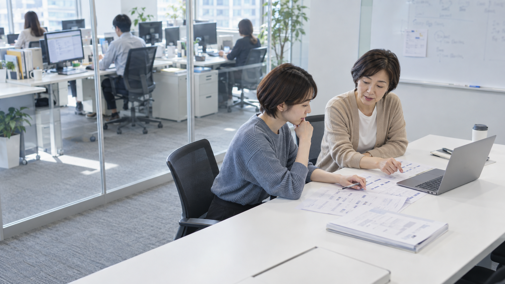 20代後半の日本人女性が小会議室での打ち合わせをしている場面